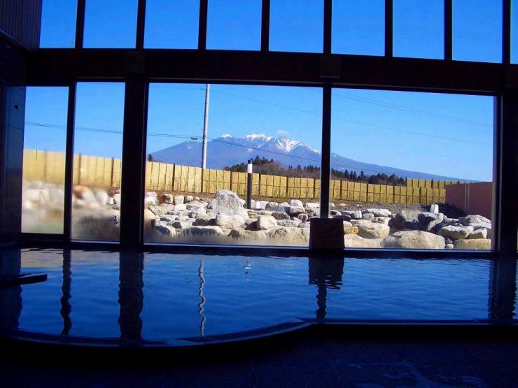 尾白の湯の内湯、大浴場を外の景色を背面にして撮った写真